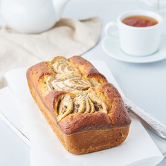 Banana bread, cake with banana, side view. The morning Breakfast with tea on a light grey background