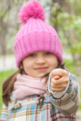 Little girl shows fig in pink hat