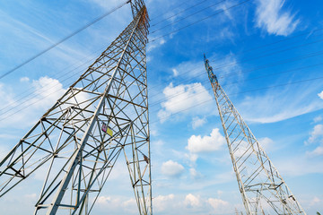 High voltage towers in the blue sky white cloud background