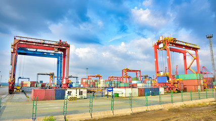 Fototapeta na wymiar Port container cranes in the background of blue sky white clouds