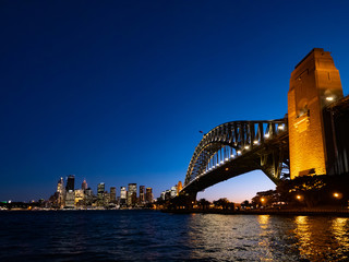 Obraz premium Harbour Bridge and Sydney city skyline at night against bright dark blue sky