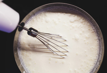 cream is whipped with a mixer in a bowl