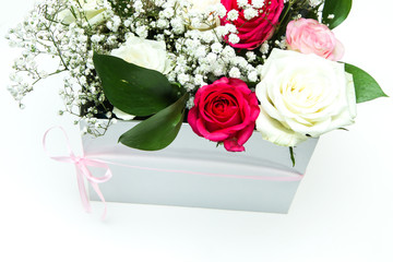 The nice roses arranged in a white gift box isolated on a white background. Very nice and romantic lookof the blooms. 
