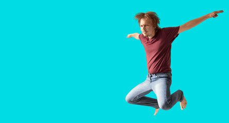 Fototapeta na wymiar teenager boy jumping dance movement on a colored blue background