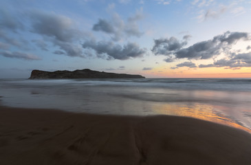 From the coast with wet sand, sea with waves, mountains there is a fantastic view of sunset sky that lights up with unbelievable colors. Nice warm autumn day. Location place Crete island, Greece.