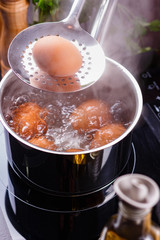 young woman in an gray apron boiled eggs