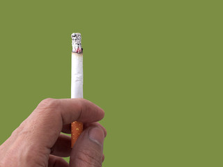 smoker fingers holding burning cigarette isolated on green with copy space