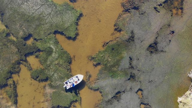 Aerial drone shot of fisherman fly fishing from boat in pristine lake in New Zealand