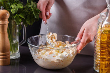 young woman in a gray aprons preparing Hawaiian salad