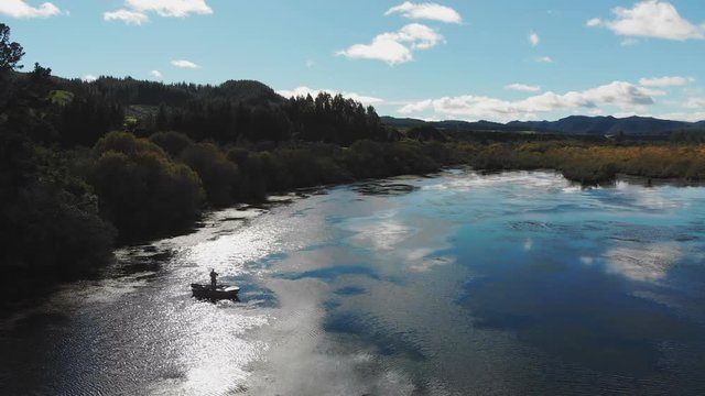 Aerial view of fisherman fly fishing from a boat on a scenic lake in New Zealand