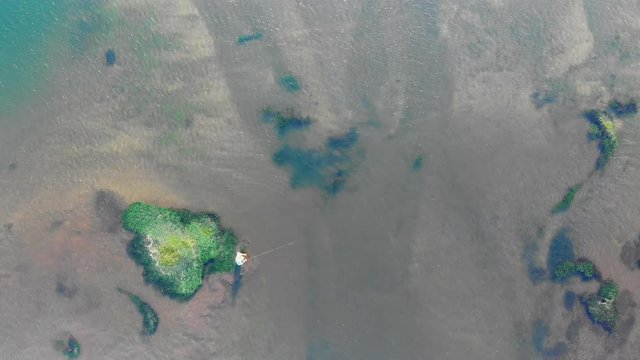 Aerial top view of fisherman fly fishing for trout in a lake in New Zealand