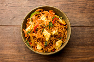 Egg Schezwan/hakka noodles, popular indochinese food served in a bowl with chopsticks. selective focus