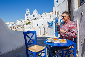 Man has Breakfast and drinks coffee