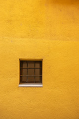 window on yellow wall