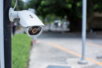 Security CCTV camera surveillance system outdoor of house. A blurred night city scape background....