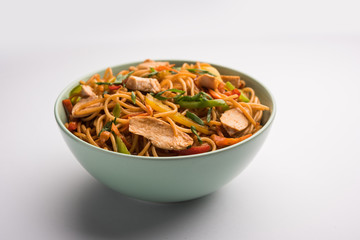 Chicken Hakka/Schezwan noodles served in a bowl with chopsticks. selective focus