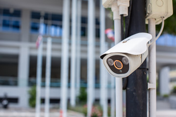 Security CCTV camera surveillance system outdoor of house. A blurred night city scape background. Modern CCTV camera on a wall. Equipment system service for safety life or asset.