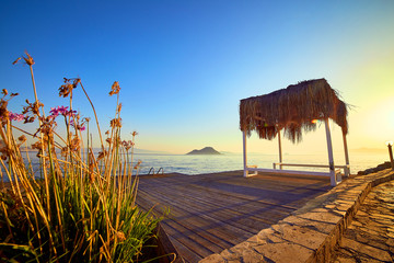 Bungalow on the sea at sunset. Wooden pavilions on the shore of a sandy beach - Bodrum, Turkey