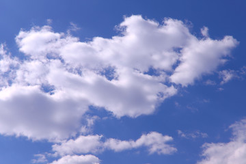 Fototapeta premium Blue sky background with white clouds on a sunny day. Nature concept. Horizontal, plenty of space for text.