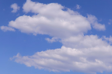 Fototapeta premium Blue sky background with white clouds on a sunny day. Nature concept. Horizontal, plenty of space for text.
