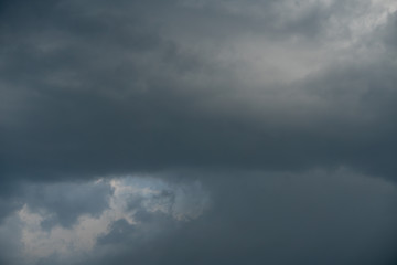 Obraz premium Dark storm clouds with softly visible sun rains. Perfect for background