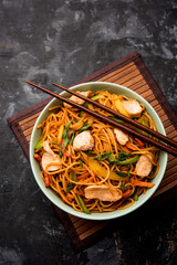 Chicken Hakka/Schezwan noodles served in a bowl with chopsticks. selective focus
