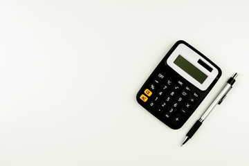 calculator and and a pen on white table. - top view with copy space.