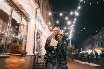 Young woman posing with a laptop on the street