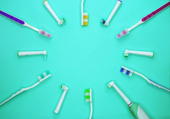 multicolored toothbrushes on a turquoise background with copy space. Flat lay. Top view.