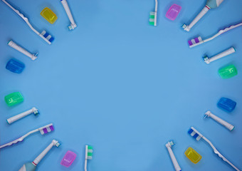 Multicolored toothbrushes on a blue background with copy space. Flat lay. Top view.