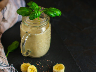 Smoothies, banana, basil, spinach, chia seeds and more are healthy food concepts. food background. top view