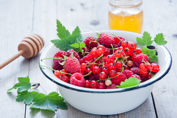 Fresh organic Red berries in a white enamel bowl
