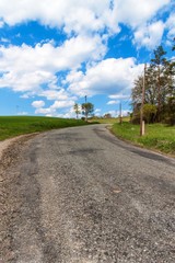 Old asphalt road in the countryside in the Czech Republic. Country road. Spring day on the road.