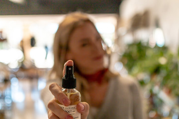 Young Woman spraying fragrance towards camera