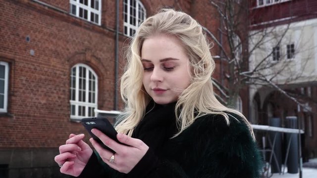 Tired and bored pretty teen girl is swiping left and right on Tinder app trying to get a match and a date.