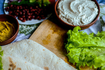 layout of ingredients for vegetable roll on dark background
