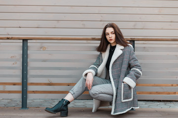 Beautiful stylish young woman in fashionable gray pants in black leather shoes in a stylish...