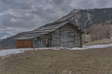 Fototapeta na wymiar old wooden hut in spring in the dolomites after a storm