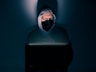Caucasian hacker in glasses looking at his note book, Concept hacking, illegal activity, breach,...