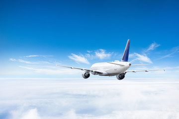 Airplane flies above the clouds high in the sky.