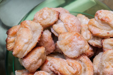 Ready-made cottage cheese biscuits sprinkled with sugar is in a plastic bowl