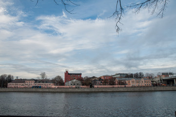 Fototapeta na wymiar Brick houses on the river bank. Luzhnetskaya embankment. Moscow