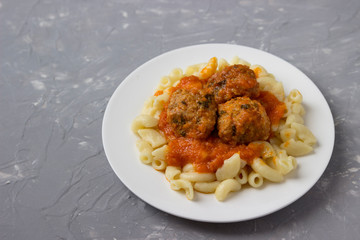 Meatballs with pasta on a plate.