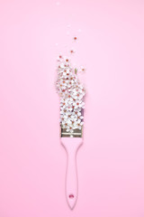 Creative composition. Paintbrush With Blossoms on pink background. Flat lay, top view, copy space