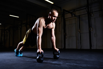 Man doing push ups on kettlebells for better strength and stability