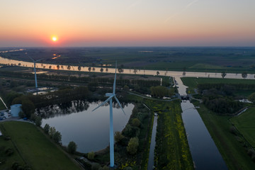 Wind turbines generating green energy during sunset as seen from above in Waalwijk, Noord Brabant, Netherlands