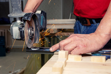 closeup man works with handheld battery circular saw cut metal