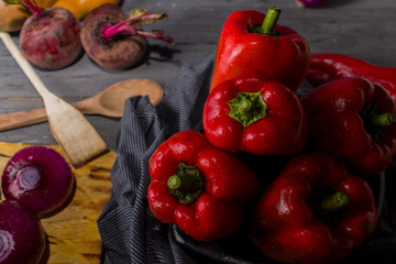 STILL LIFE OF RED PEPPERS ON A RUSTIC WOODEN TABLE