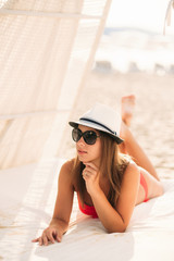 Beautiful girl on the coast in a hut. Sexy lady in pink swimsuit