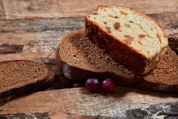 Top view of assorted fresh baked bread in slices on wooden plank